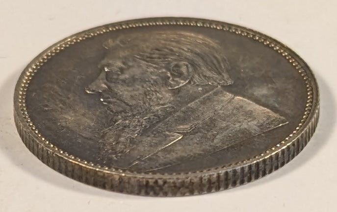 SOUTH AFRICA, Zuid Afrikaansche Republik ~ 1897 ~ Shilling ~ Bust of Paul Kruger left ~ Value divides date in wreath, Z. AFRIK. REP. above. ~ Y-4, KM-5 ~ Nice unc., a few marks