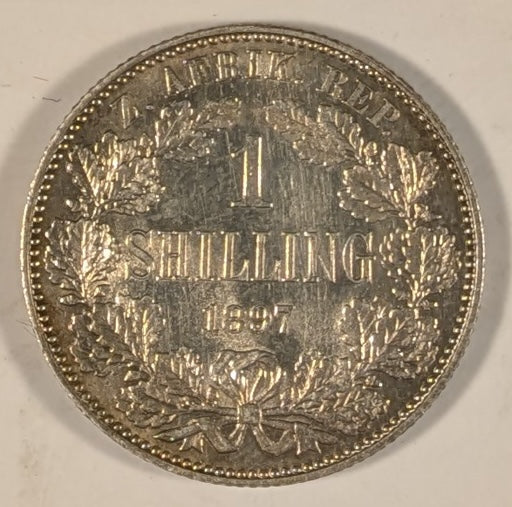 SOUTH AFRICA, Zuid Afrikaansche Republik ~ 1897 ~ Shilling ~ Bust of Paul Kruger left ~ Value divides date in wreath, Z. AFRIK. REP. above. ~ Y-4, KM-5 ~ Nice unc., a few marks