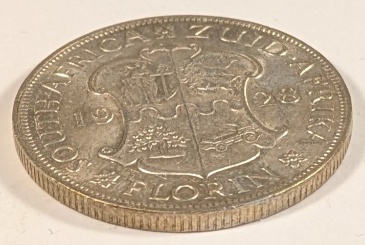 SOUTH AFRICA, Union of So. Africa, Dominion ~ 1928 ~ 1 Florin ~ Crowned bust of George V left ~ Arms divides date. Denomination as FLORIN. ~ Y-20, KM-18 ~ EF